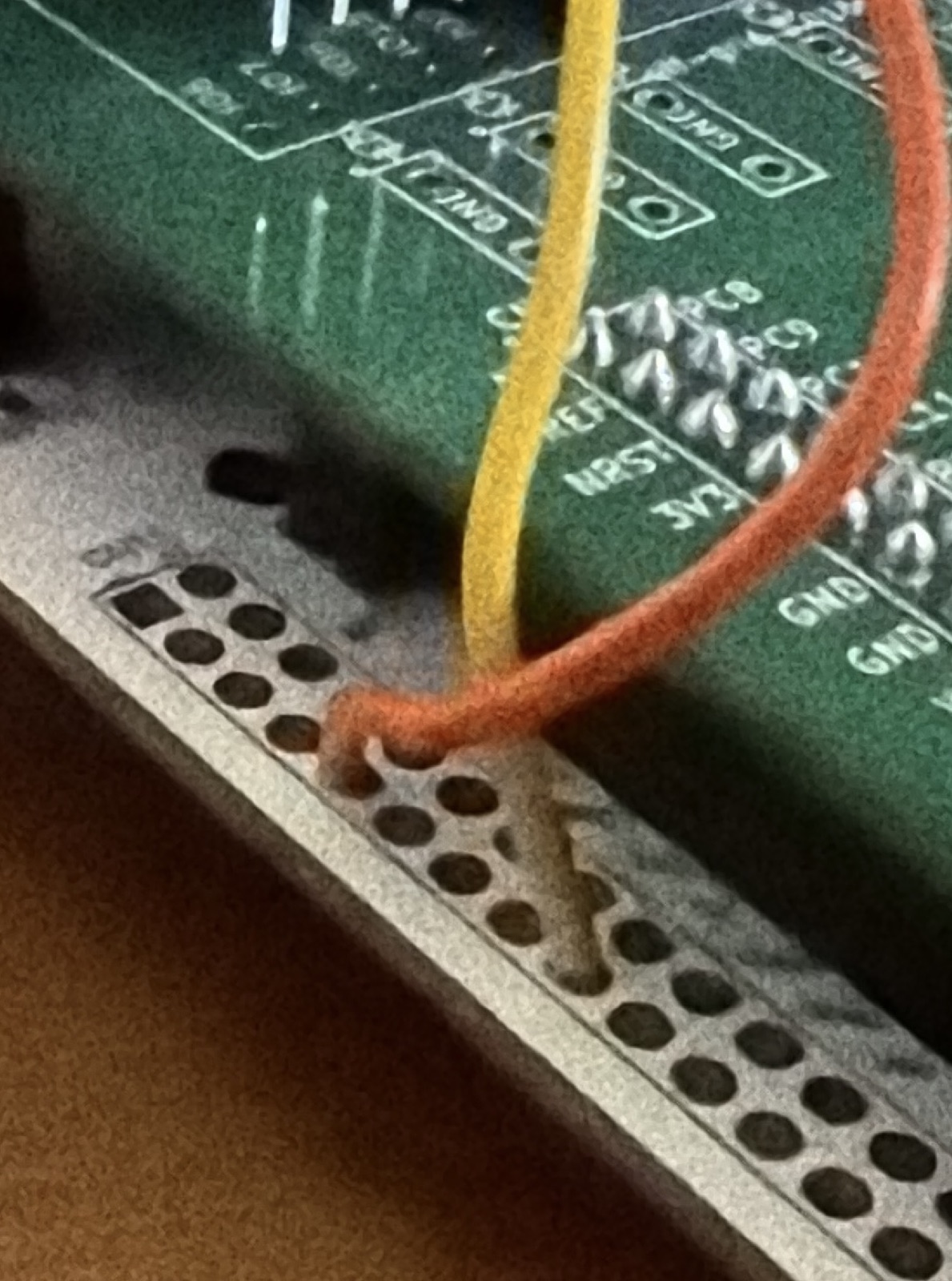 The orange and yellow bodge wires leaving the Feather's D24 and D25 pads
